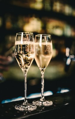 Zwei Gläser mit prickelnden Schaumwein stehen auf einem Tisch 