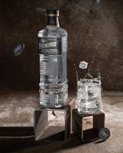 Eine Nemiroff DeLuxe Flasche und ein Glas stehen elegant auf einem kleinen Podest.