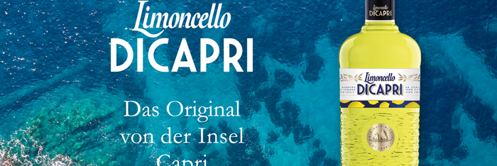 Die gelbe Limoncello DiCapri Flasche vor der wunderschönen blauen Küste von Capri. Das Original der Insel Capri