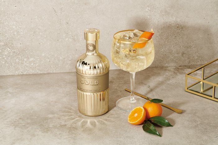 Stilvolles Getränk mit goldener Flasche und Glas