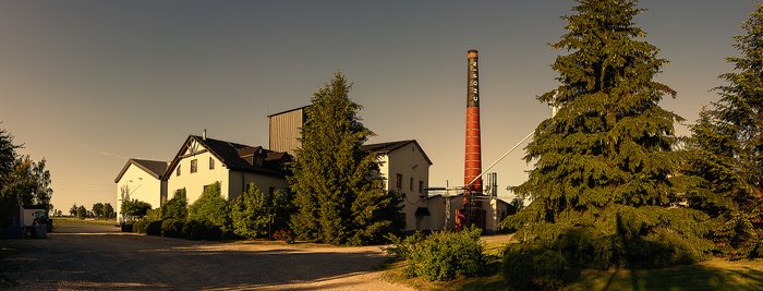 Zu erkennen ist die Chopin Vodka Distillery umgeben von Bäumen.