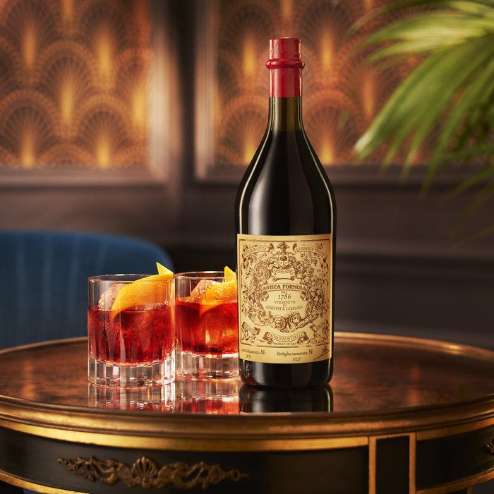 Zwei Gläser Negroni und eine Flasche Antica Formula auf einem Tisch