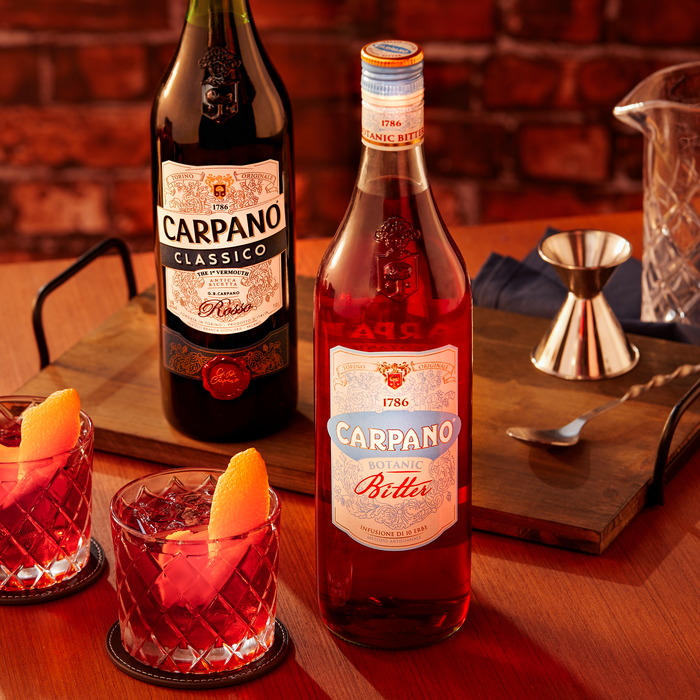 Carpano Bitter und Carpano Classico auf einem Tisch mit zwei Gläsern Negroni